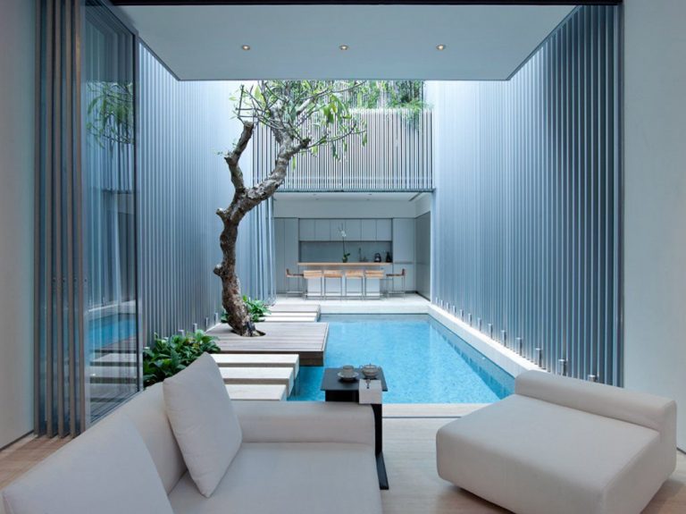desain kolam renang indoor di antara ruang keluarga dan ruang makan